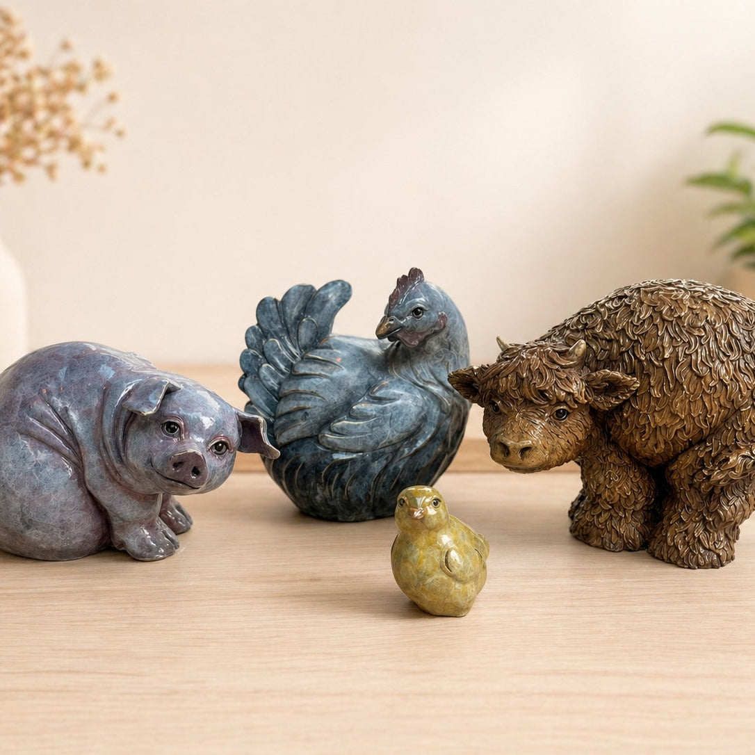 collection of bronze sculptures of farmyard animals including a pig, a cow, a chick and a chicken